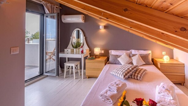 A bedroom with a bed, bedside tables, a desk with a mirror, and a window. - Alisahni Villa, Villa (Chania)