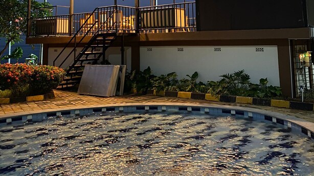 A building with a covered outdoor area, a swimming pool, and a staircase leading to an upper level. - Nemuru Grand Anyer Palazo (Anyer)