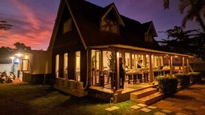 A two-story house with a porch and a small garden area. - Nemuru Grand Anyer Palazo (Anyer)