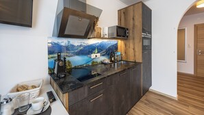 Una cocina moderna con estufa integrada, microondas y un amplio ventanal con vistas panorámicas a la montaña.