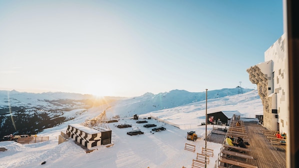 A snow-covered ski resort with a wooden deck and cabins. - GALAAXY Mountain Hostel (Falera)