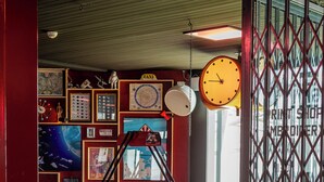 A room with a fire truck play area, a clock, and various framed pictures on the walls. - GALAAXY Mountain Hostel (Falera)