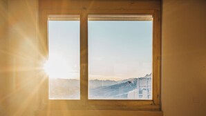 A room with a bed and a window overlooking a snowy landscape. - GALAAXY Mountain Hostel (Falera)