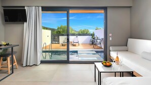Una sala de estar moderna con un gran ventanal corredera que da a un área exterior con piscina y mobiliario.