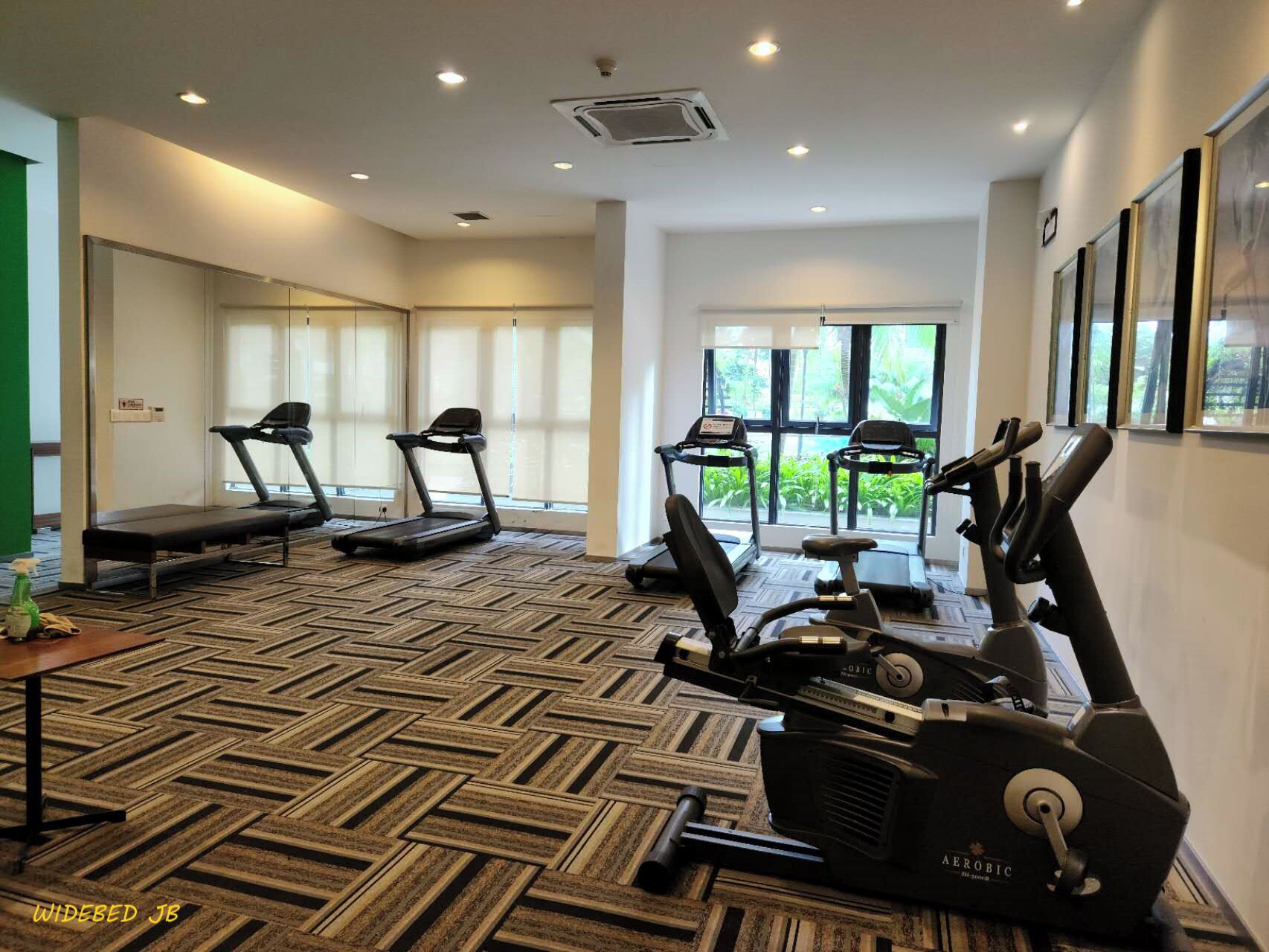 A gym with treadmills, elliptical machines, and a massage table.