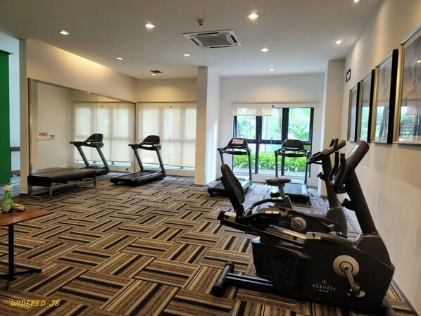 A gym with treadmills, elliptical machines, and a massage table.