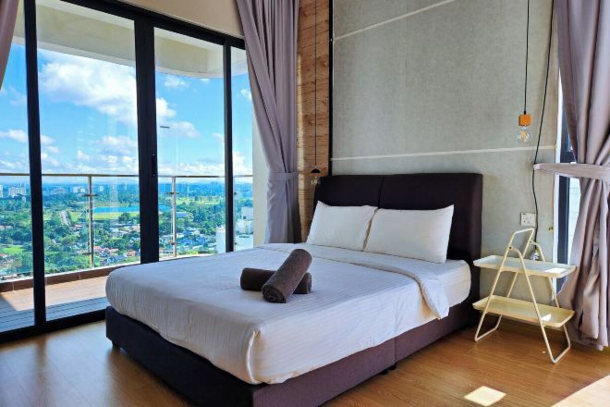Un dormitorio moderno con una cama grande, vistas a la ciudad y un balcón.