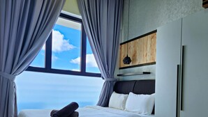 A bedroom with a large window, a bed with white linens, and a wooden headboard. - Country Garden Danga Bay by Widebed JB (Johor Bahru)
