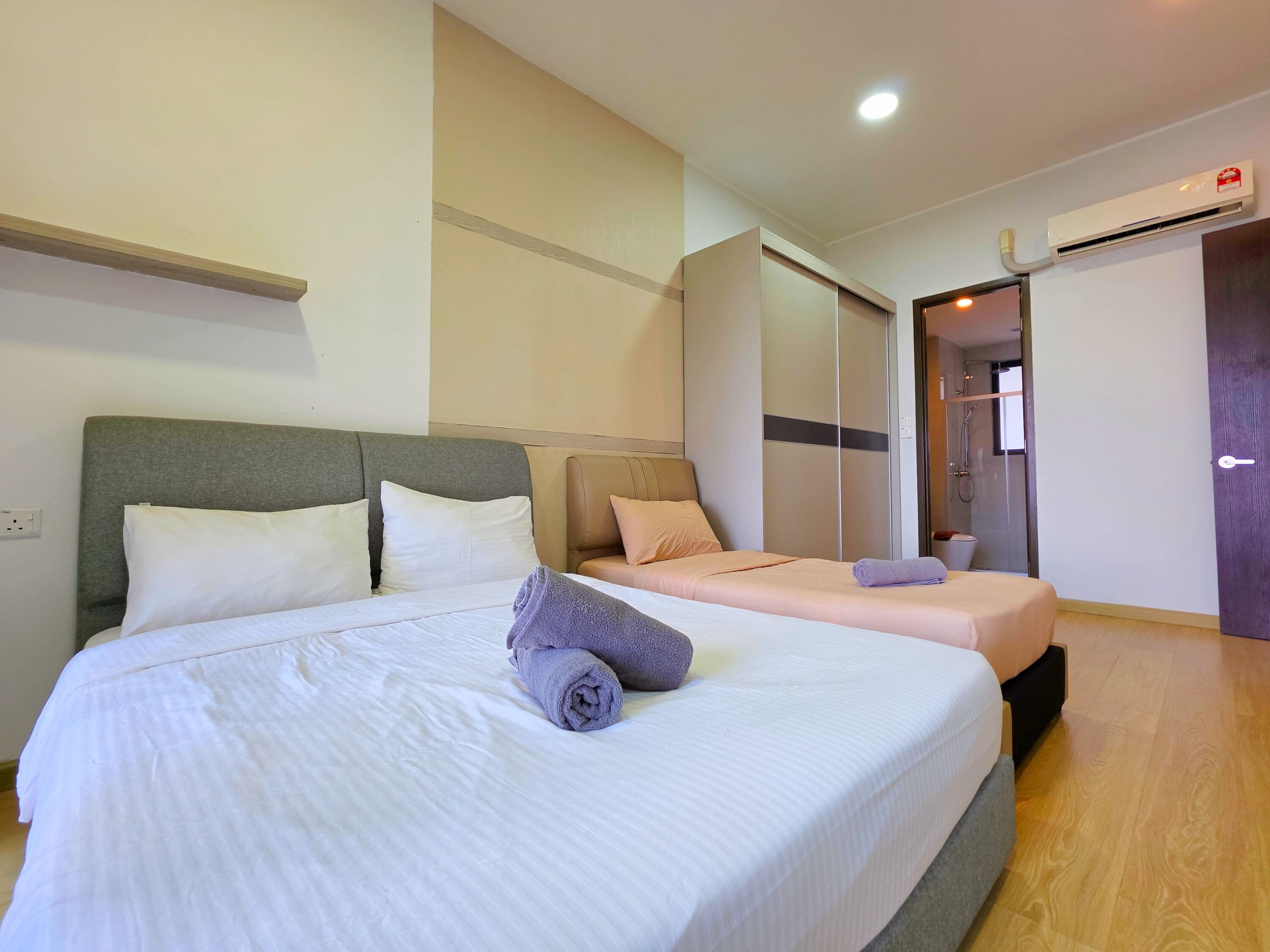 Une chambre d’hôtel équipée d’un lit, d’une table de chevet, d’une armoire et d’un appareil de climatisation.