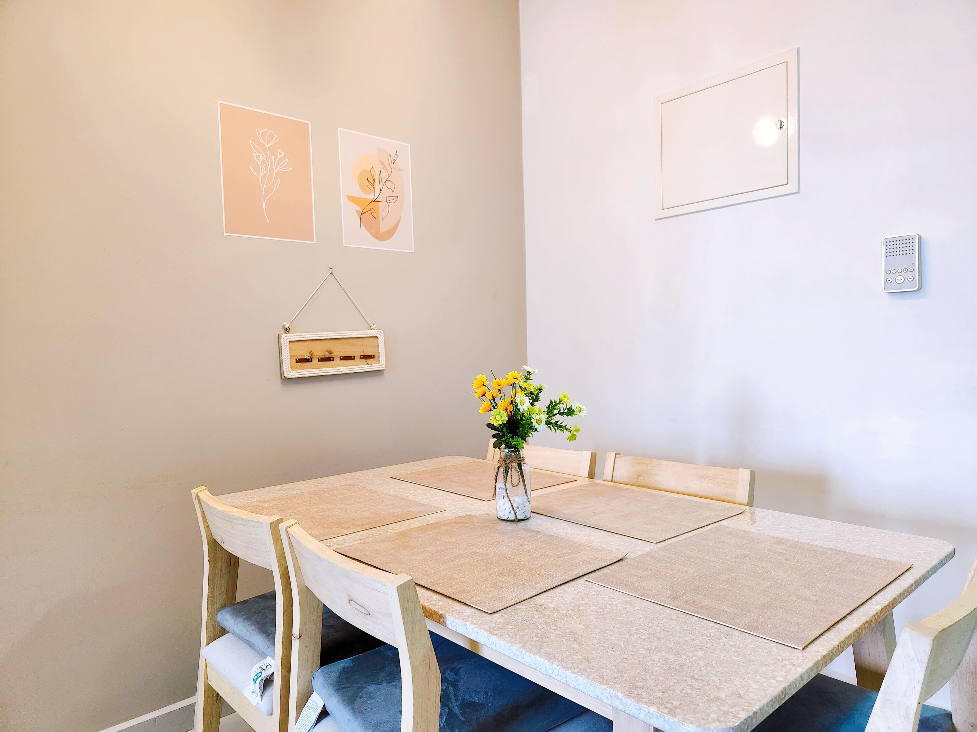 Comedor con mesa, sillas y decoración en la pared.