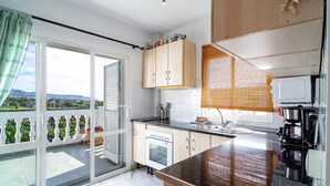 Una cocina moderna con una isla grande, horno empotrado y cafetera.