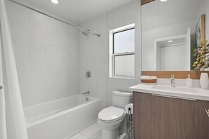 Ein modernes Badezimmer mit Badewanne, Toilette und Waschbecken.