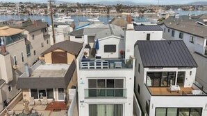 Un edificio residencial moderno con techo plano, ventanas grandes y un balcón.