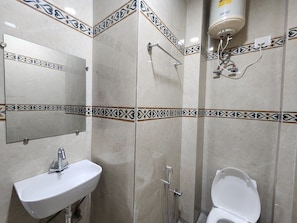 A bathroom with a sink, mirror, toilet, and shower. - Cottage Yes Sir Dx (New Delhi)