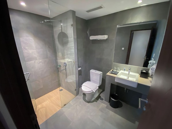 Un baño moderno con ducha de vidrio, inodoro y lavamanos.