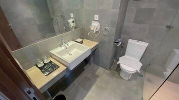 A modern bathroom with a large sink, toilet, and a mirror.