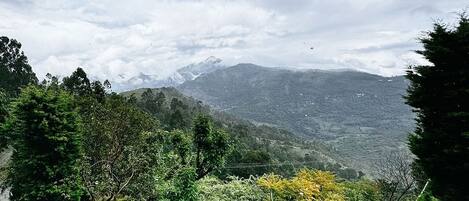 Un paisaje montañoso con abundante vegetación y cielo nublado.