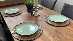 A dining table set with plates, a candle, and a potted plant. - Cozy studio guest house near the center & trade fair (Nürnberg)