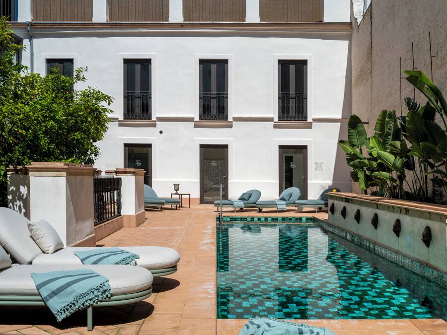 Una piscina al aire libre, sillones reclinables de piscina