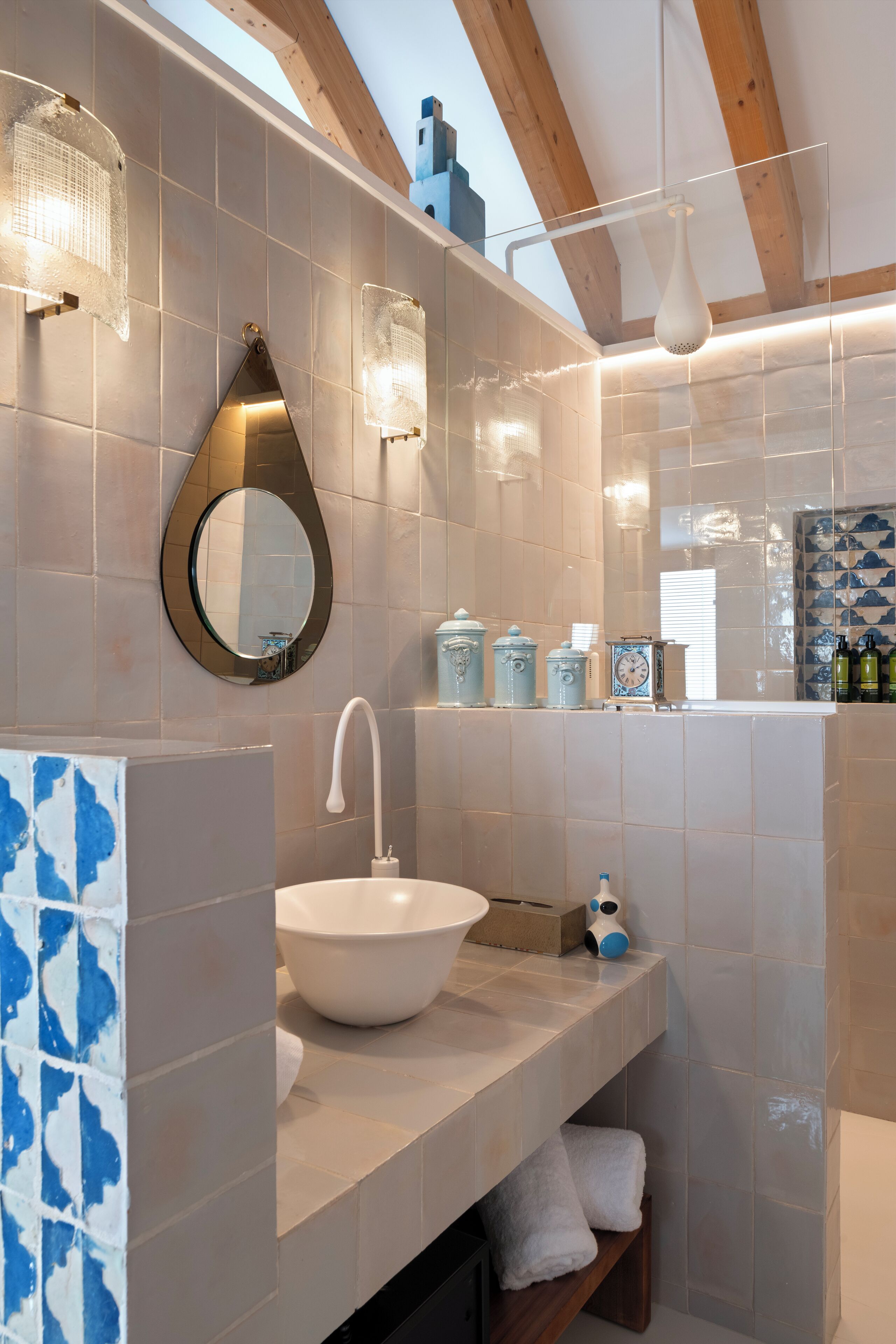 A modern bathroom with a large white sink, a mirror, and a towel rack.