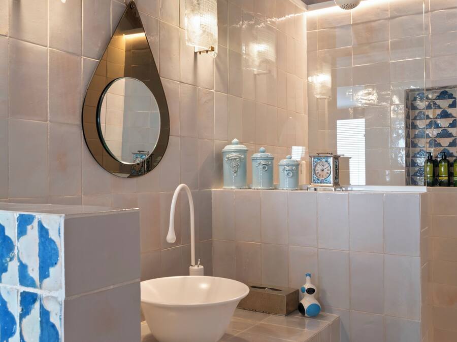 A modern bathroom with a large white sink, a mirror, and a towel rack.