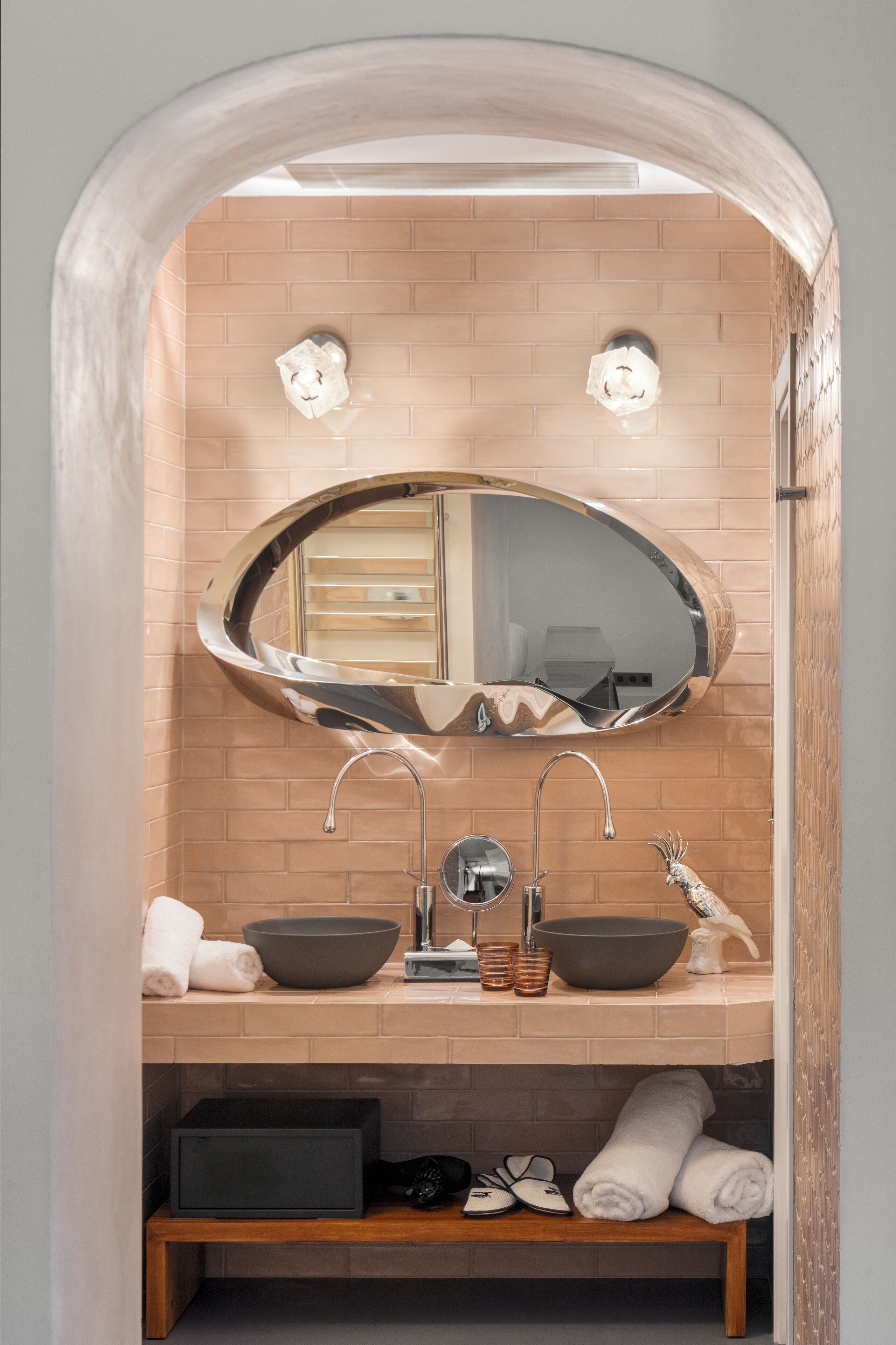 Un baño con lavamanos doble, un espejo grande y un perchero para toallas.