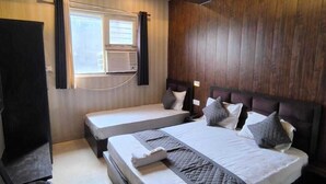 Un dormitorio moderno con dos camas, un ventilador de techo y una ventana con cortinas.