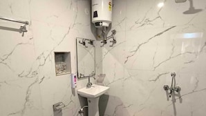 Un baño con inodoro, lavamanos y ducha.