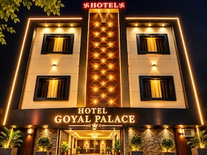 A hotel entrance with a prominent sign reading 'HOTEL GOYAL PALACE' and a modern facade with illuminated windows and a central light fixture. - Hotel Goyal Palace (Agra)