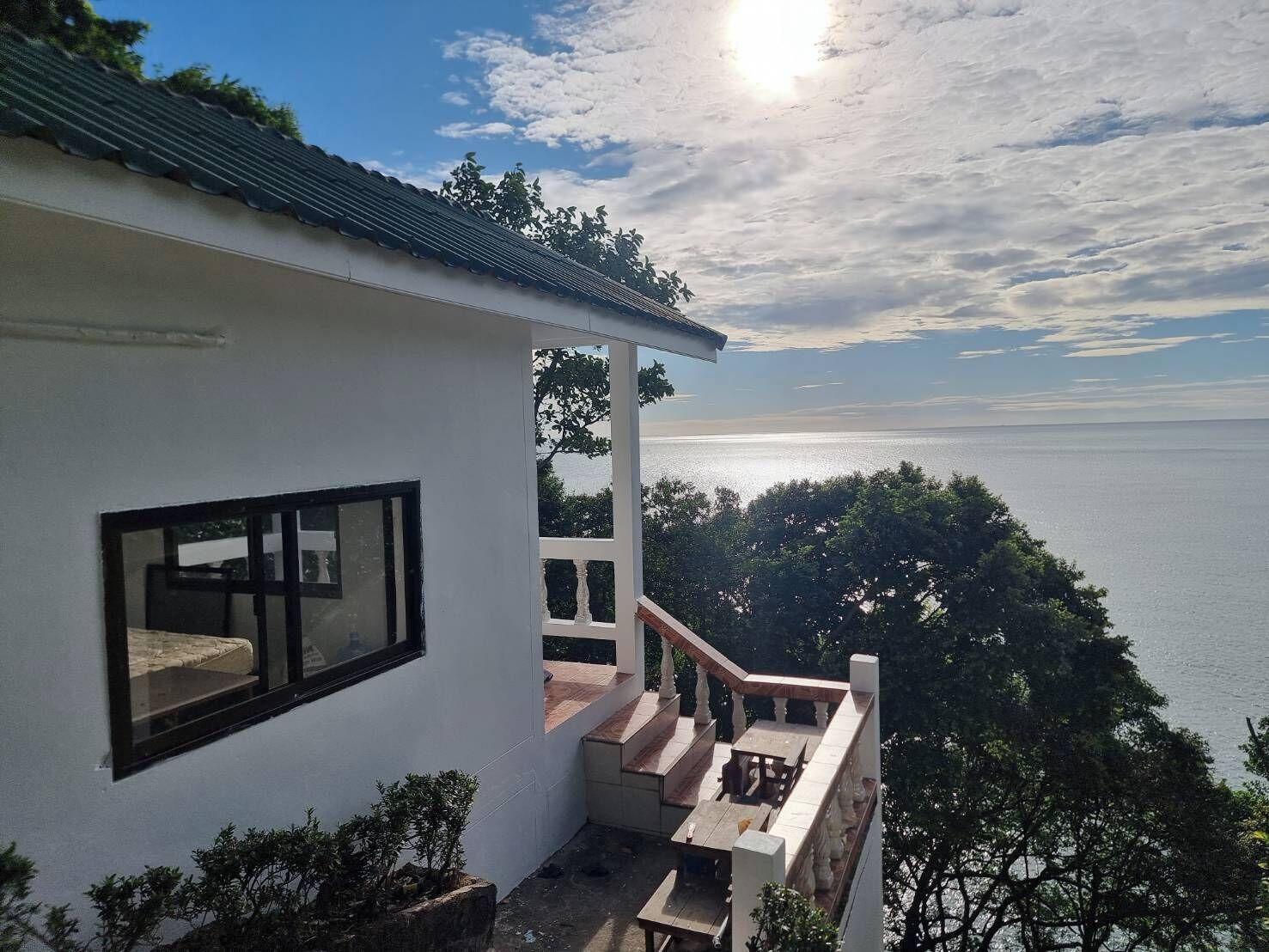 A white building with a balcony overlooking a body of water.