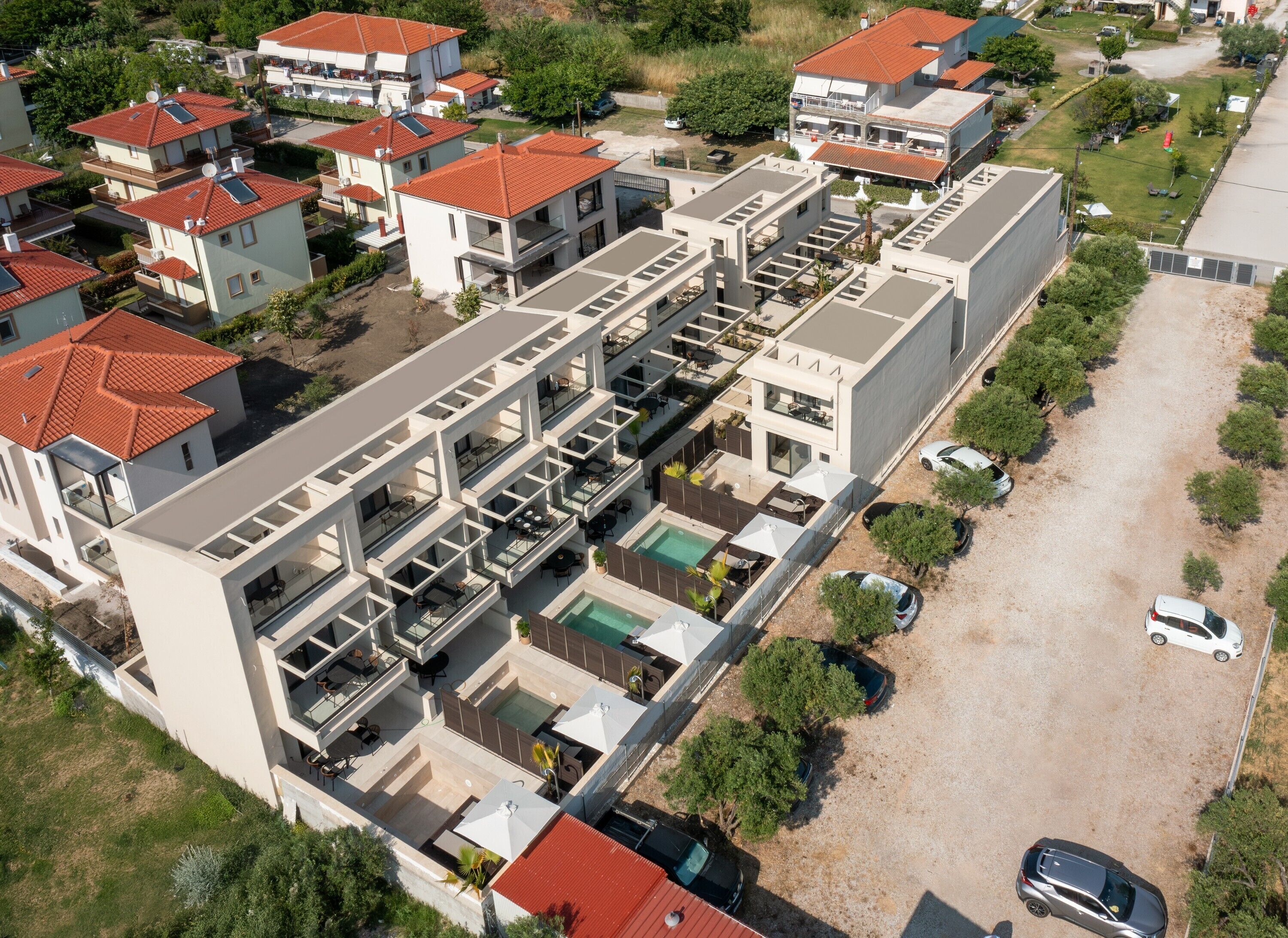 Un moderno edificio residencial de varios pisos con piscina en la azotea y zonas de estar al aire libre.