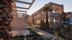 A modern multi-story residential building with outdoor seating areas and well-maintained landscaping.