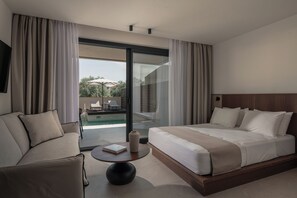 Habitació d'hotel moderna amb un llit gran, un sofà, una taula petita i una porta corredissa de vidre que dona a una zona de piscina.
