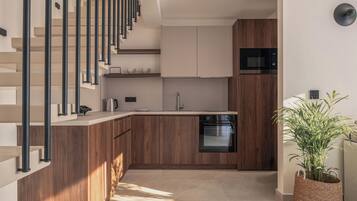 Una cocina moderna con armarios de madera, horno empotrado y microondas de acero inoxidable.