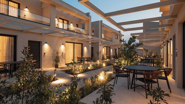 A modern outdoor patio area with multiple seating arrangements and potted plants.