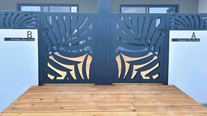 Una entrada de hotel moderna con una puerta metálica decorativa con motivos de hojas.