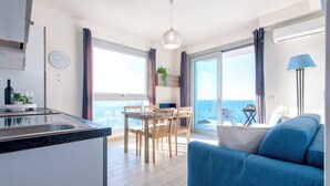 A modern apartment with a kitchen, dining area, and a balcony with a view. - Sardinia Re - Miramare 14 Sea View (Castelsardo)