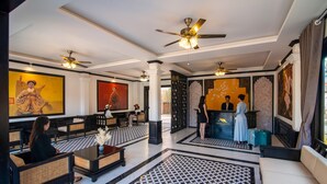 A spacious lobby with high ceilings, ceiling fans, and a reception desk. - Vang Luang Hotel (Luang Prabang)