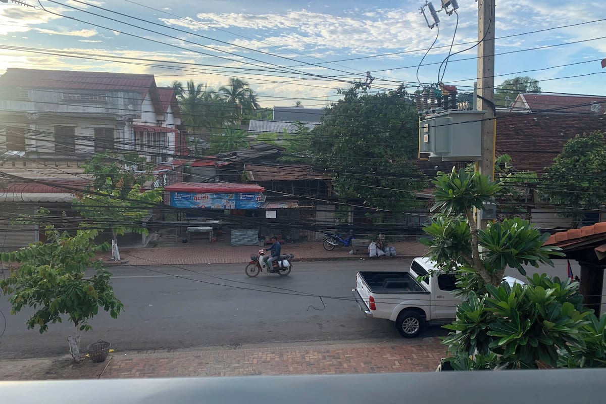 A street scene with buildings, a parked white pickup truck, and a motorbike.