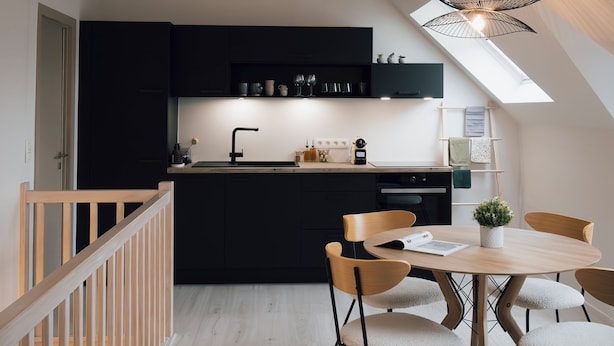 Una cocina moderna con tragaluz, mesa de comedor de madera y sillas.