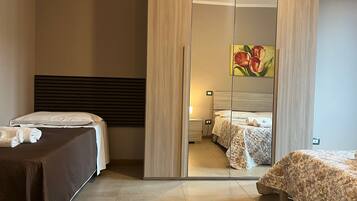 Ein Hotelzimmer mit einem großen Spiegel, zwei Betten, einem hölzernen Kopfteil und einem Blumenbild.