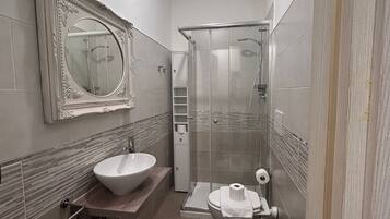 Un bagno funzionale con lavandino, WC e doccia.