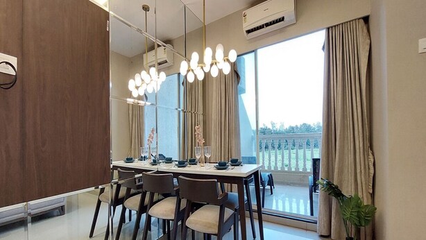 Une salle à manger moderne avec une grande table dressée pour six personnes, une grande fenêtre avec des rideaux et une plante en pot.