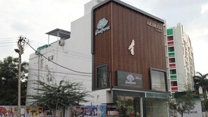 A building with a large sign for 'GreenParrot' and 'Akshaya Tower'. - Hotel Green Parrot (Madurai)