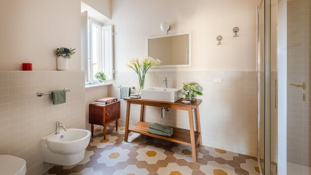 Een badkamer met een wastafel, een toiletbril en een spiegel.