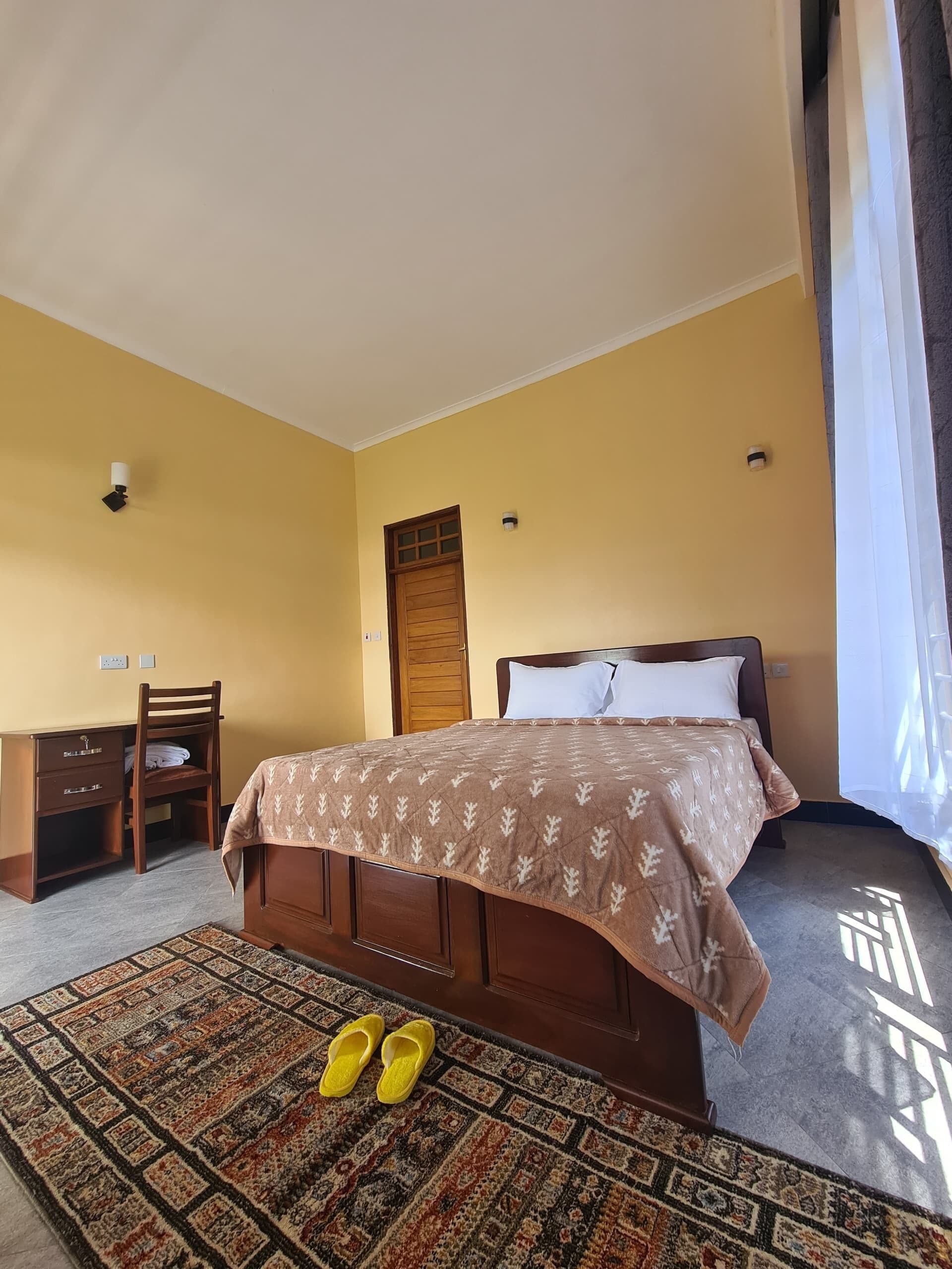 Una habitación de hotel con cama, escritorio y silla.