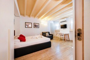 Ein Schlafzimmer mit Bett, Schreibtisch, Stuhl und Fernseher.