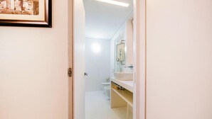 A bathroom with a toilet, a sink, and a mirror.