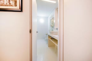 A bathroom with a toilet, a sink, and a mirror.