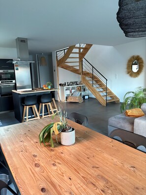 Eine moderne Küche mit Einbauofen und einer Holztreppe, die zu einem Erker führt.